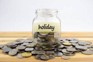 Image of a jar that says 'Holiday' surrounded by coins