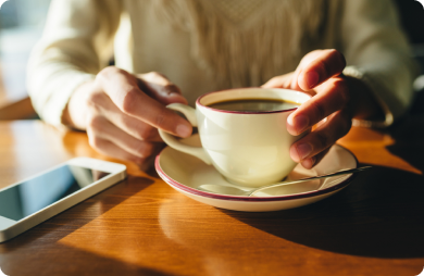 Young person's hands holding a coffee mug